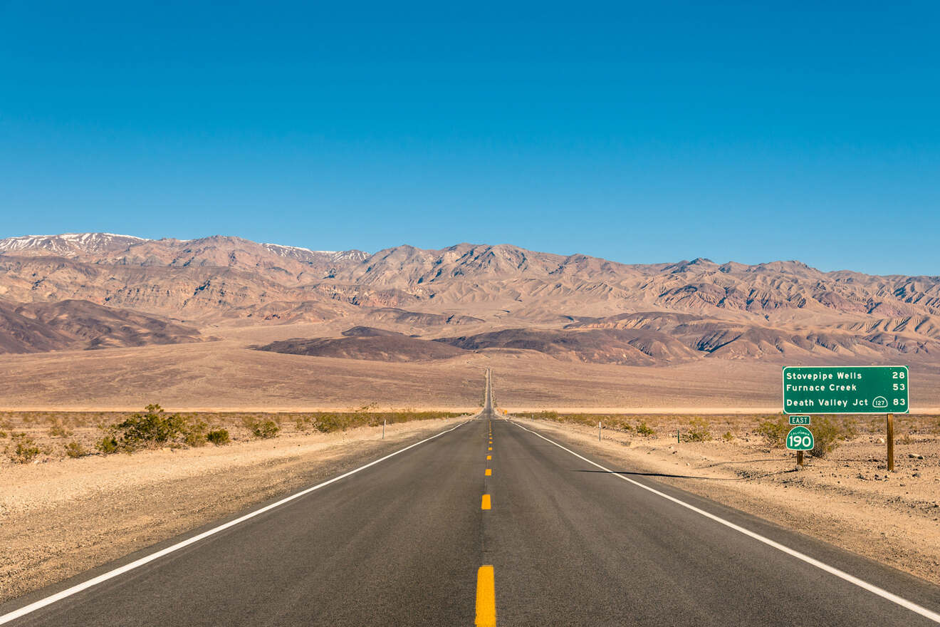 a highway in the middle of a desert with mountains in the background